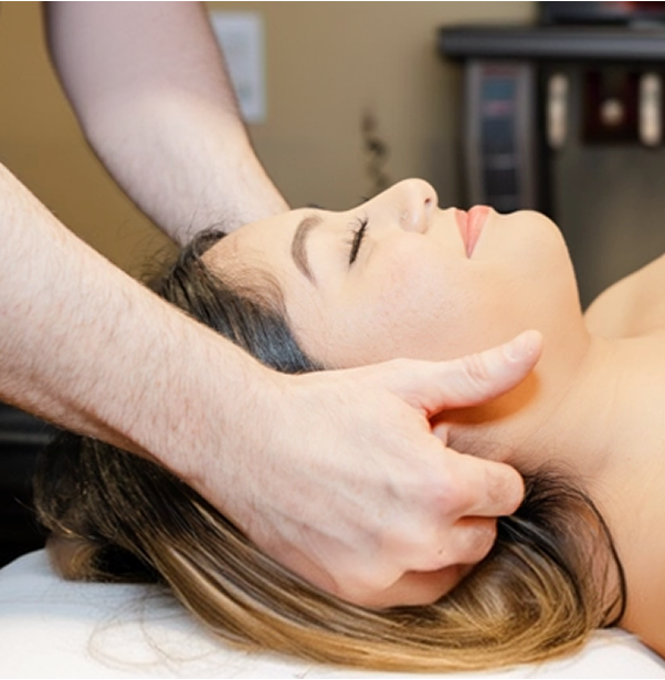 Chiropractor performing head and neck adjustment on relaxed patient