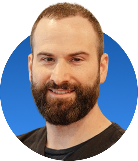 Bearded chiropractor in black shirt smiling against blue background
