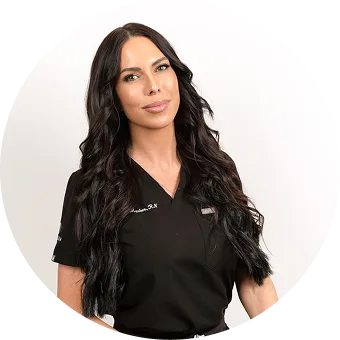 Woman with long dark wavy hair wearing black v-neck medical top