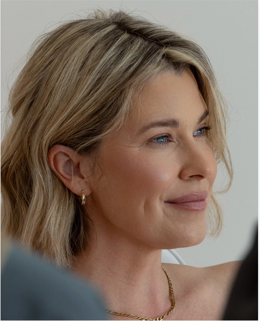 Woman in profile showing facial structure, fine lines, and subtle aging on cheeks and forehead