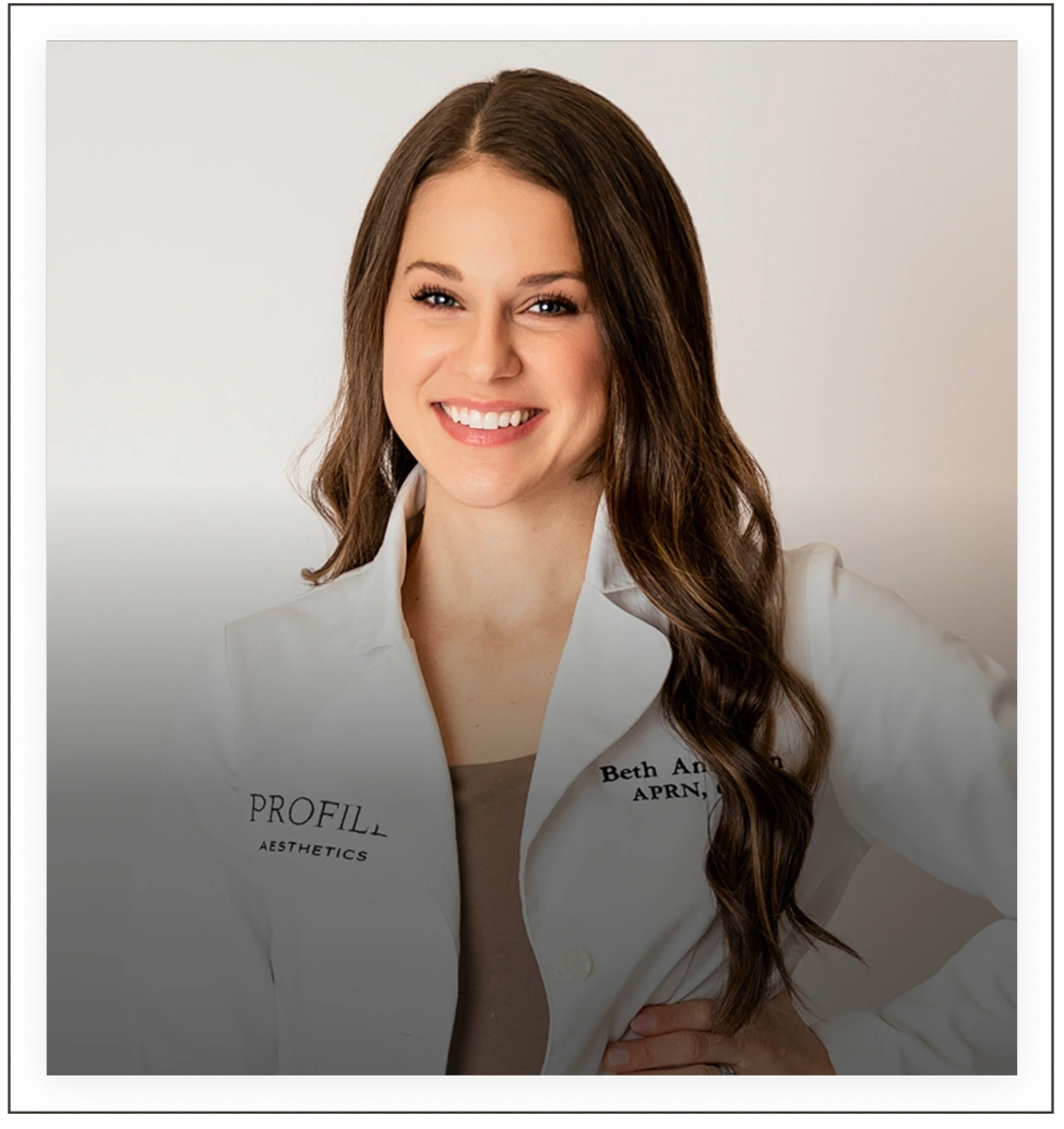 Beth Anderson, APRN, wearing white Profile Aesthetics coat, smiling at camera
