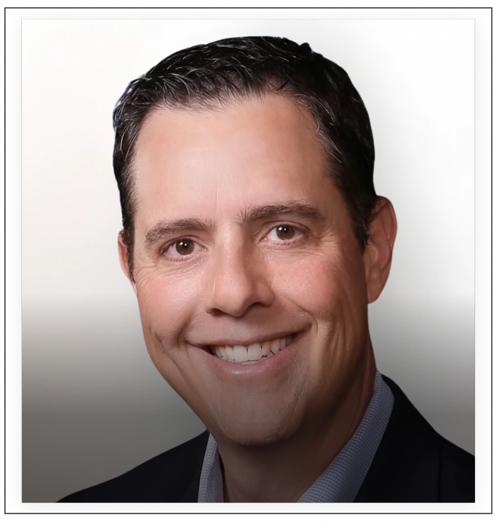 Brit Ferrell headshot, man smiling in blue shirt against neutral background