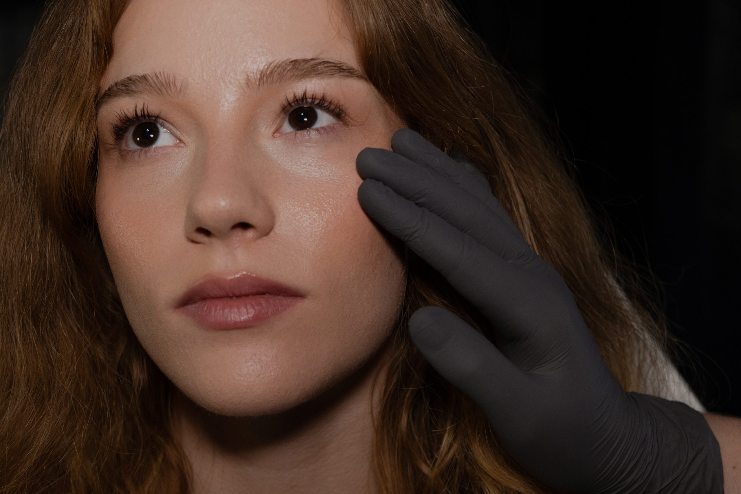 Injector at Profile Aesthetics in Scottsdale assessing a woman's cheek before facial balancing