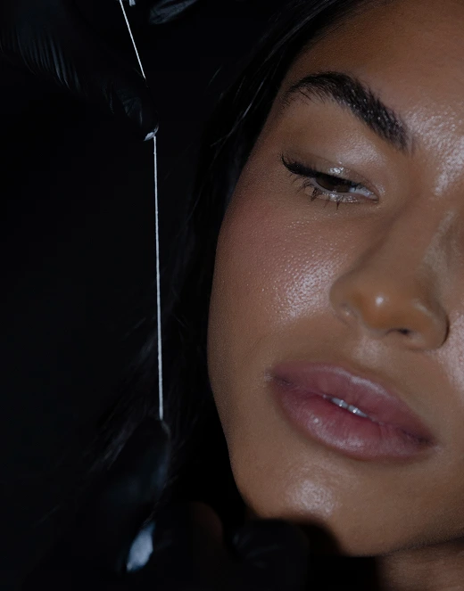 Close-up of woman's face showing skin texture and defined eyebrow