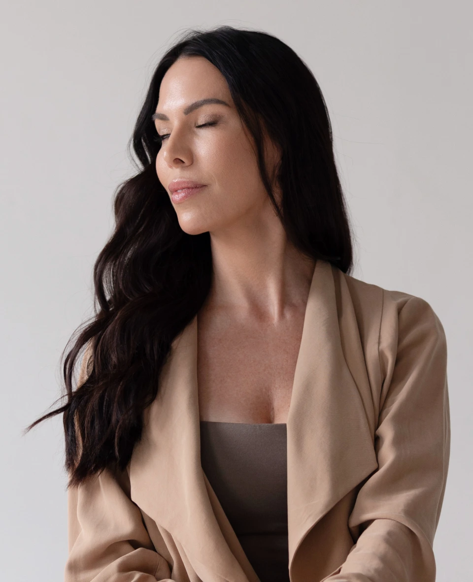 Woman with long dark hair looking down, appearing relaxed and healthy