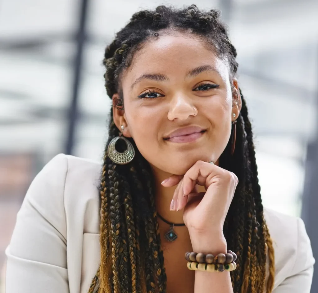 Smiling teen girl with braided hair posing in a modern office setting