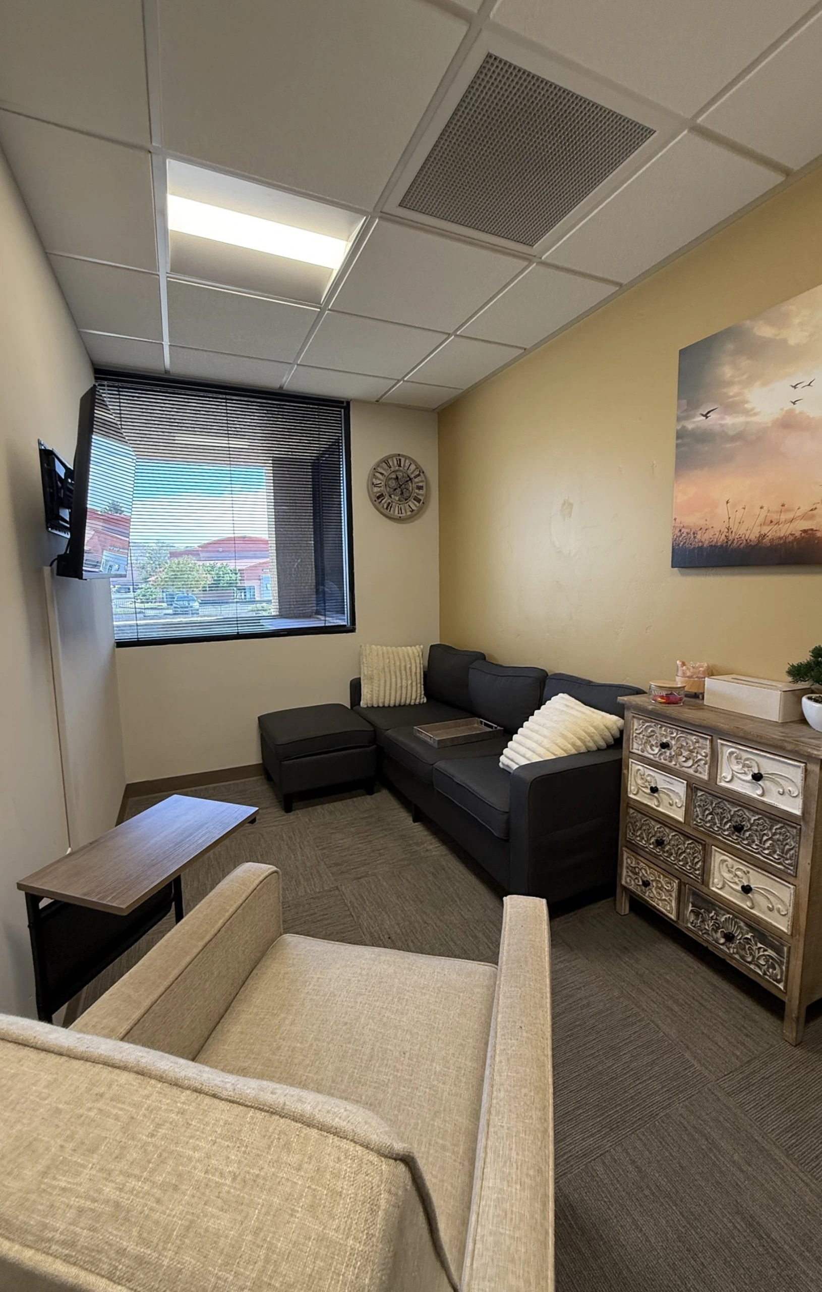 Calm therapy room with a sofa, armchairs and soft lighting