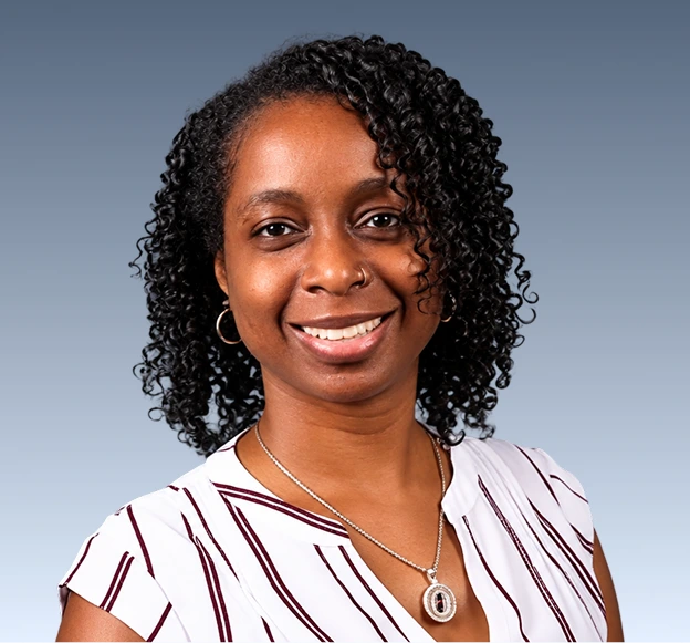 Progressive Movement Inc. team member smiling at camera against blue background