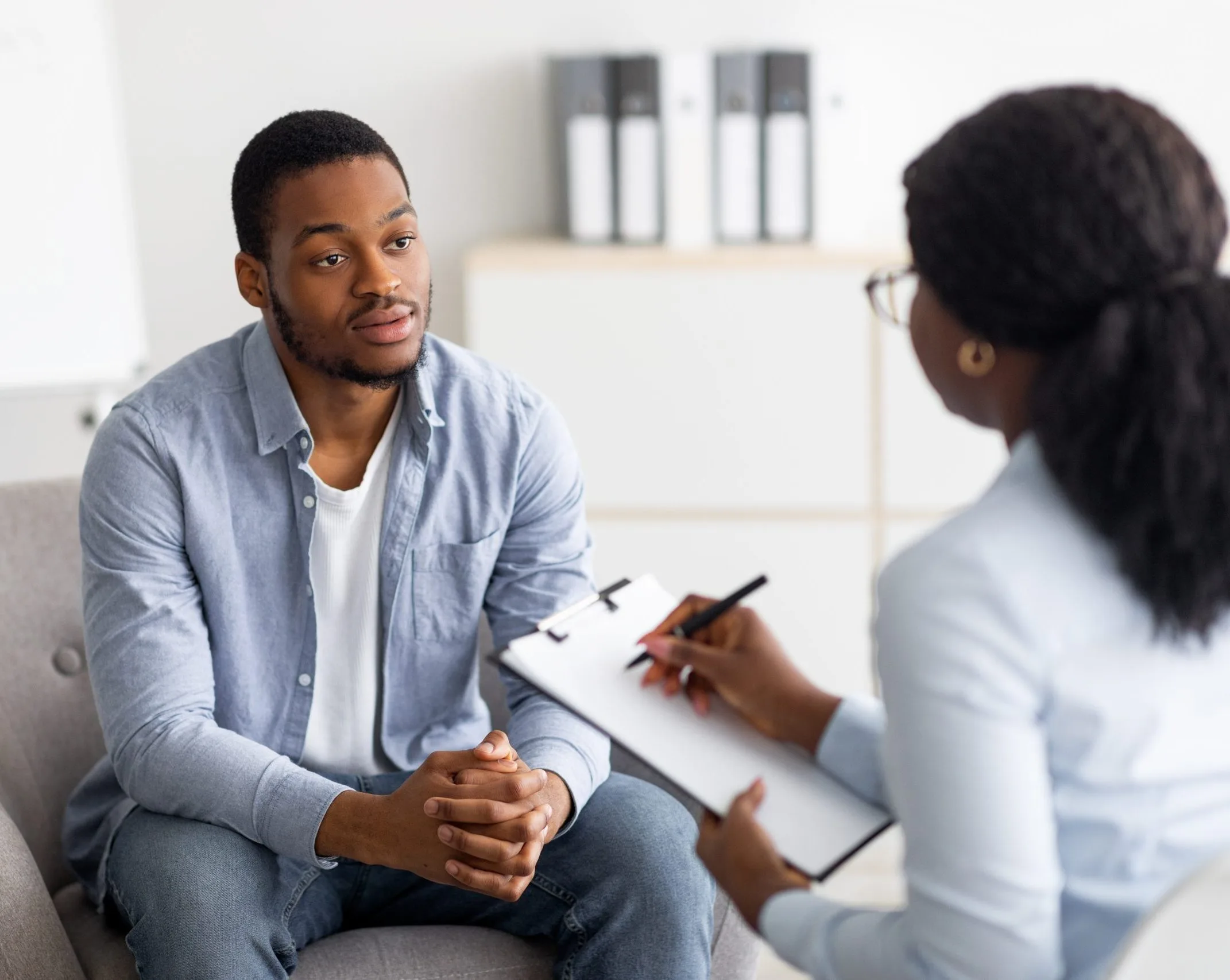 Man speaking with a therapist taking notes during a session in Redlands, CA