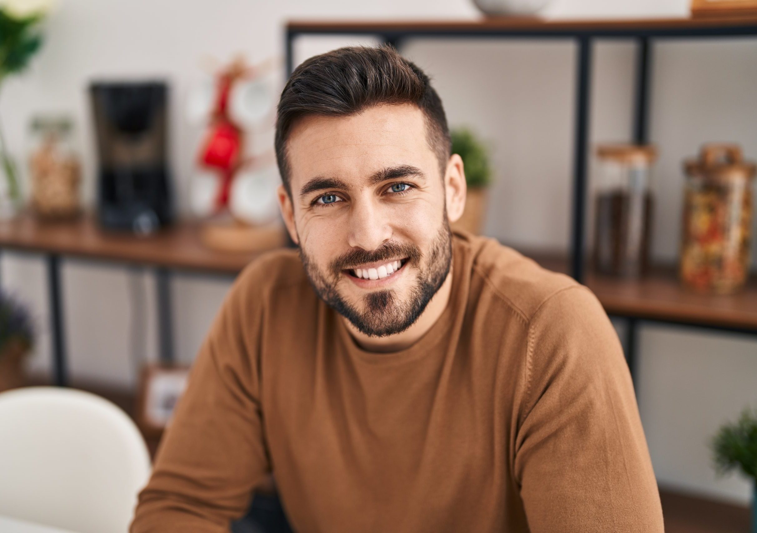 Smiling man in a brown sweater feeling confident after therapy with Progressive Movement Inc.