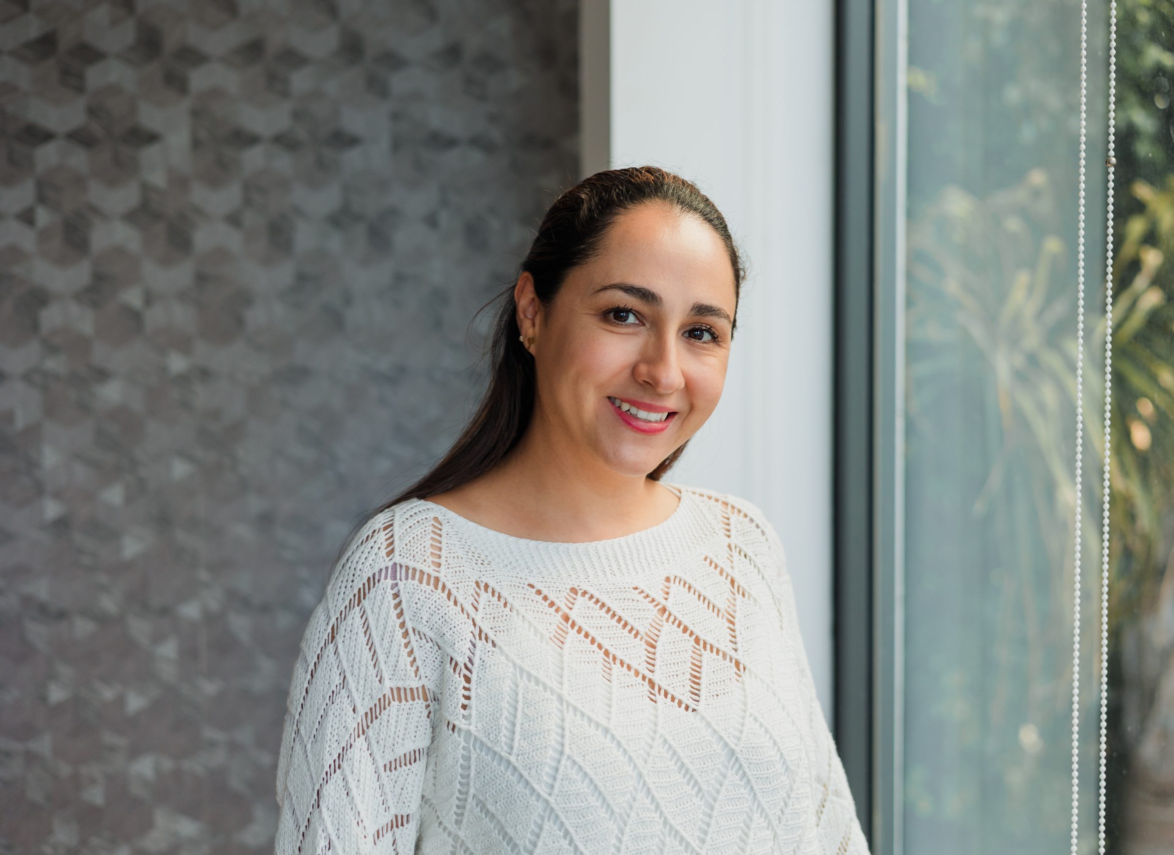 Smiling woman by a window, representing therapy in Moreno Valley, CA