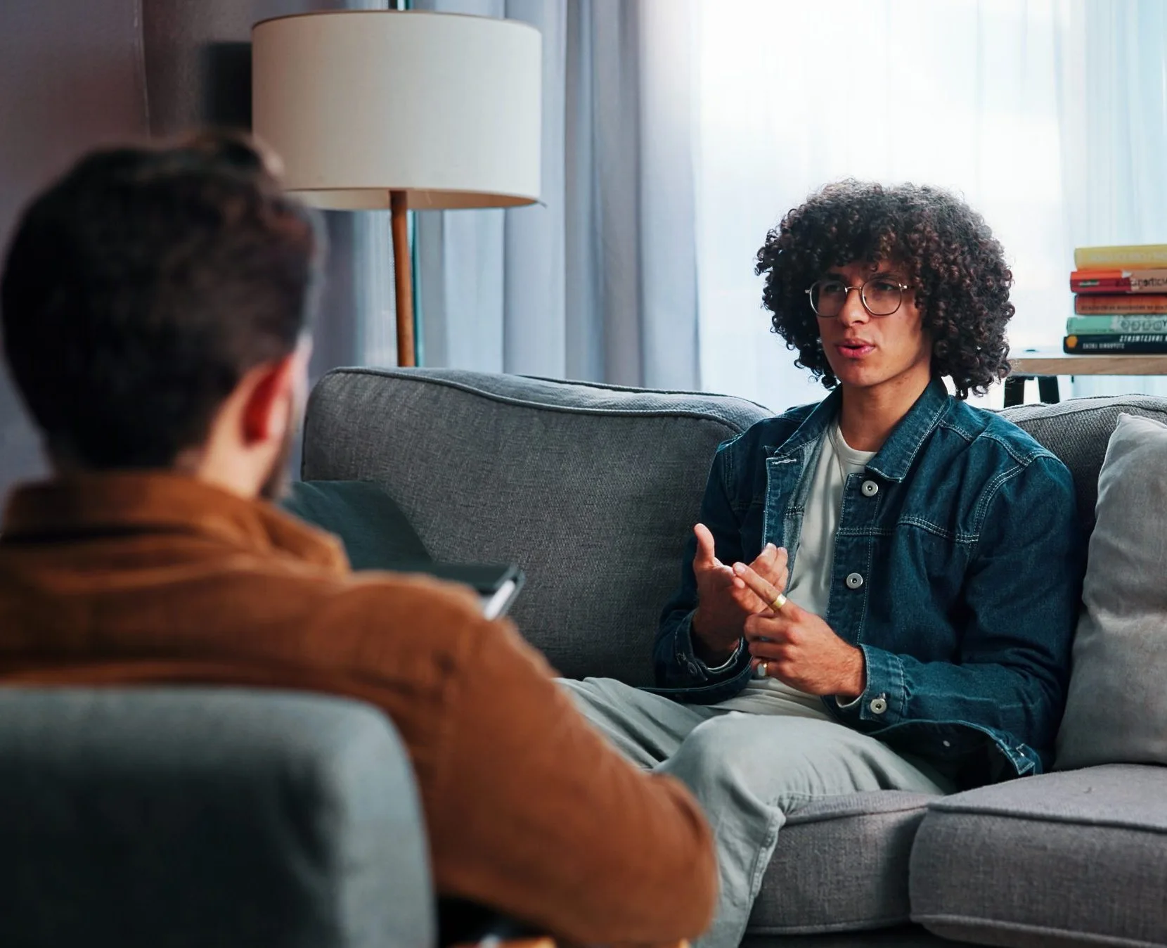 Therapist and patient in conversation on a couch during a counseling session in a bright office