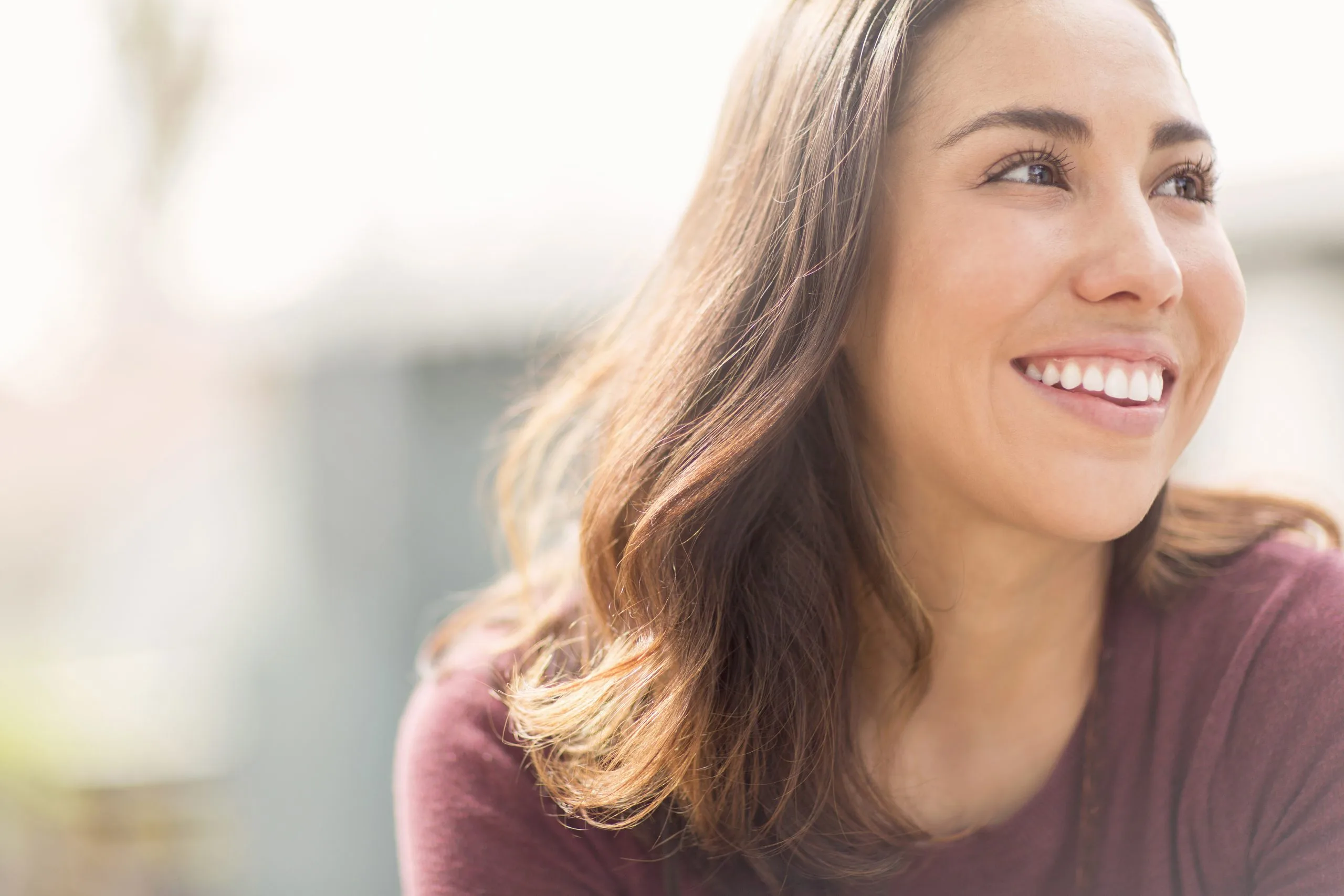 Woman smiling and looking off to the side in natural light