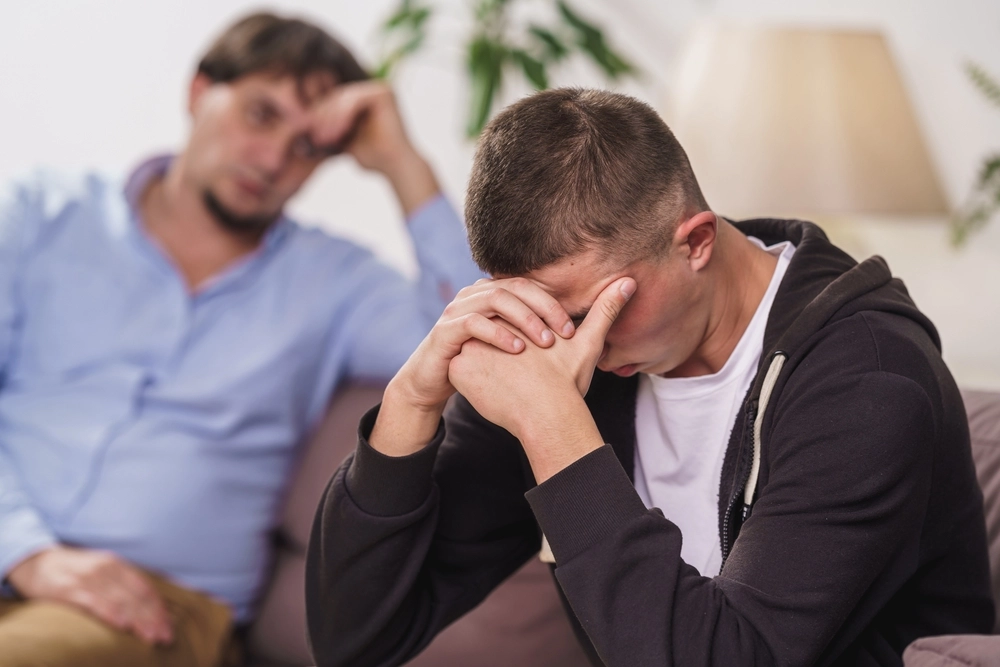 Frustrated Young Man Is Sitting At Home On Couch Difficult