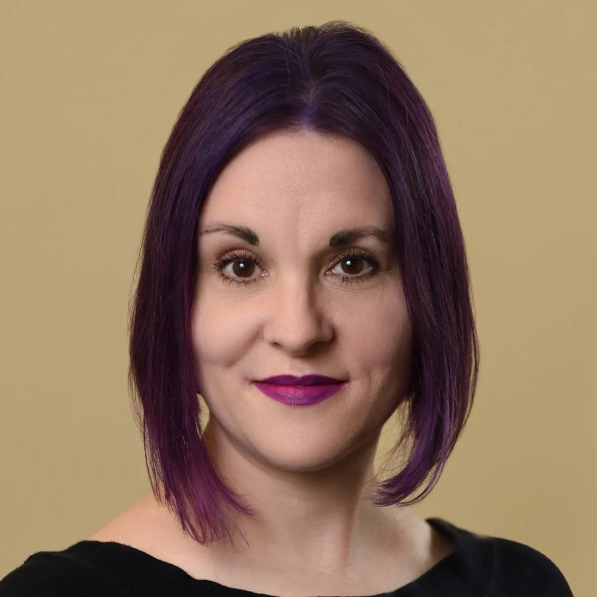 Darcy Desautels, LICSW, professional headshot against a beige background