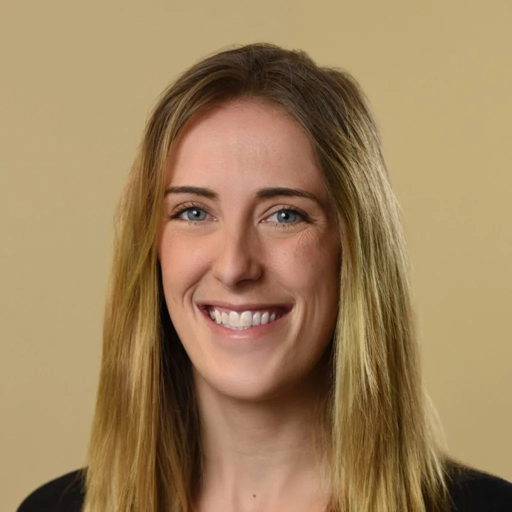 Emily Polutchko, LMHC, smiling at camera against neutral background