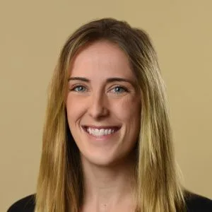 Emily Polutchko, LMHC, smiling at camera against neutral background