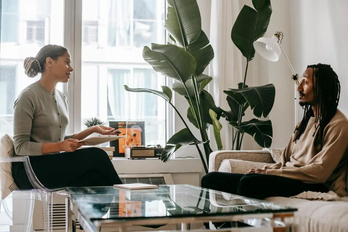 Therapist consulting male client in modern office setting