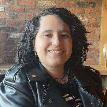 Nashley Nieves, LADC I, LCSW, smiling at the camera in front of a brick wall