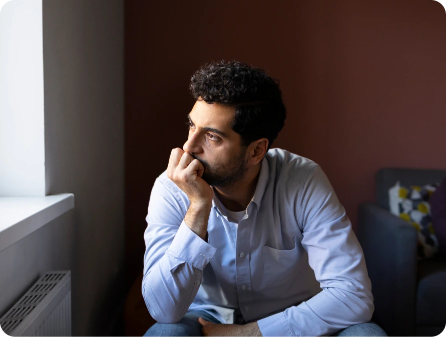 Man sitting by a window, lost in thought