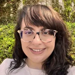 Nicole Marshall Concha, LMHC, smiling at camera wearing glasses