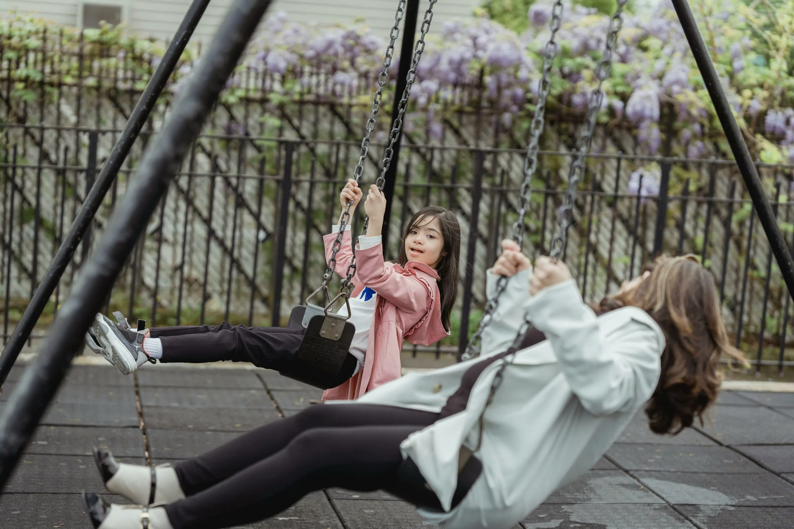 Child and adult enjoying a swing together at the park