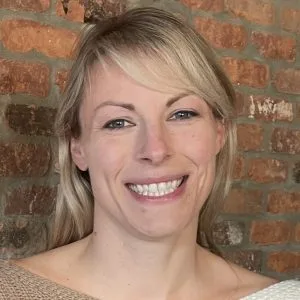 Shannon Raslan, LMHC, smiling at camera against a brick wall