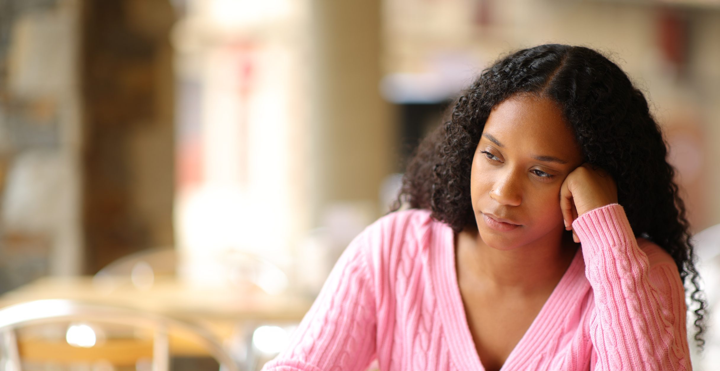 Woman resting her head on her hand, struggling to focus