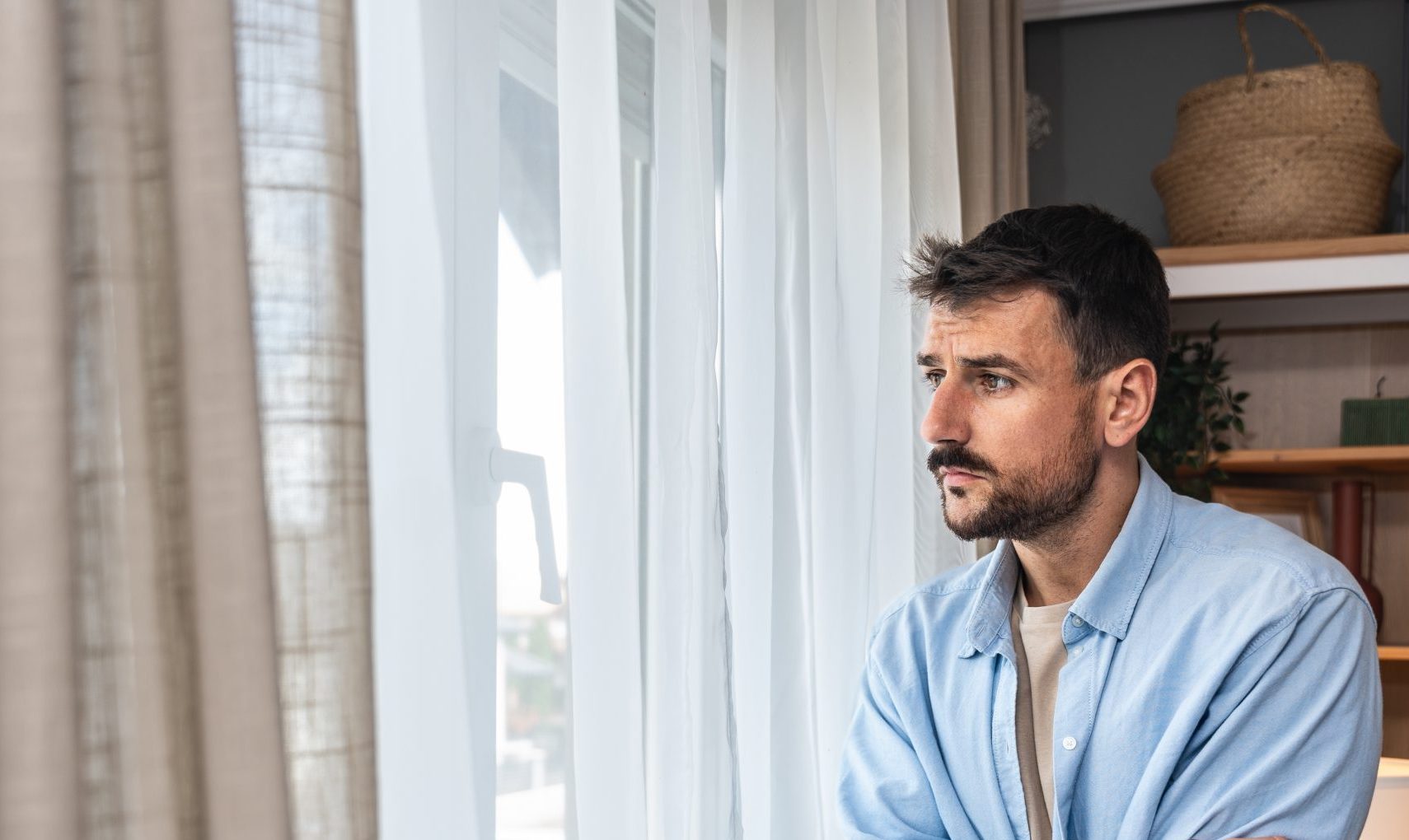 Worried man sitting by a window