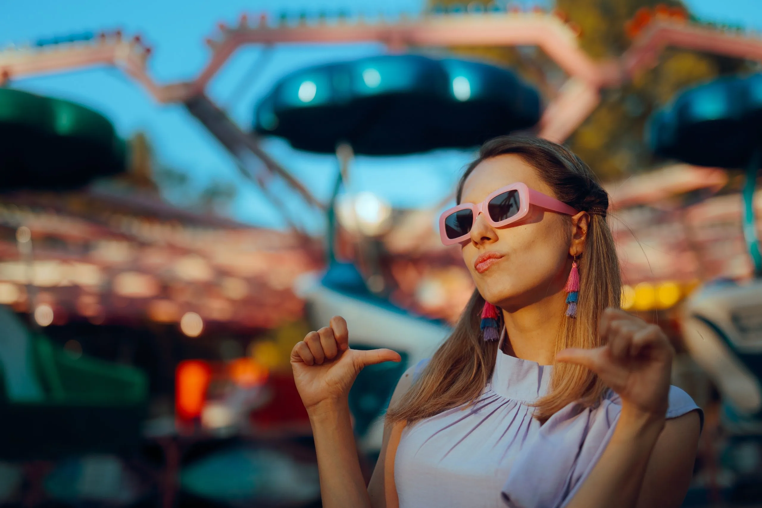 Woman in sunglasses pointing at herself