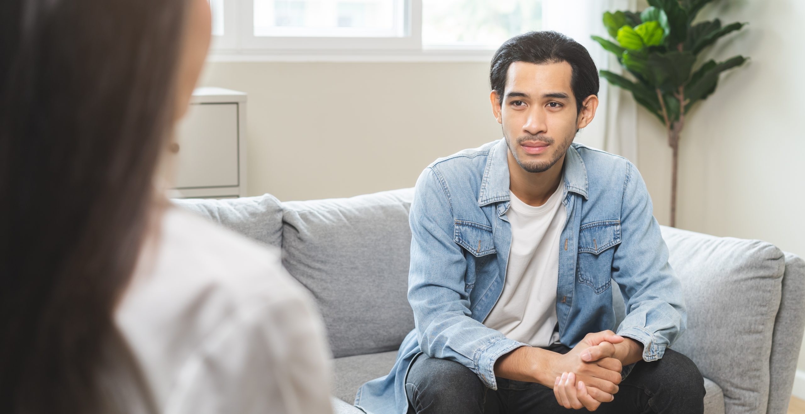 Young man on a couch talking with a therapist