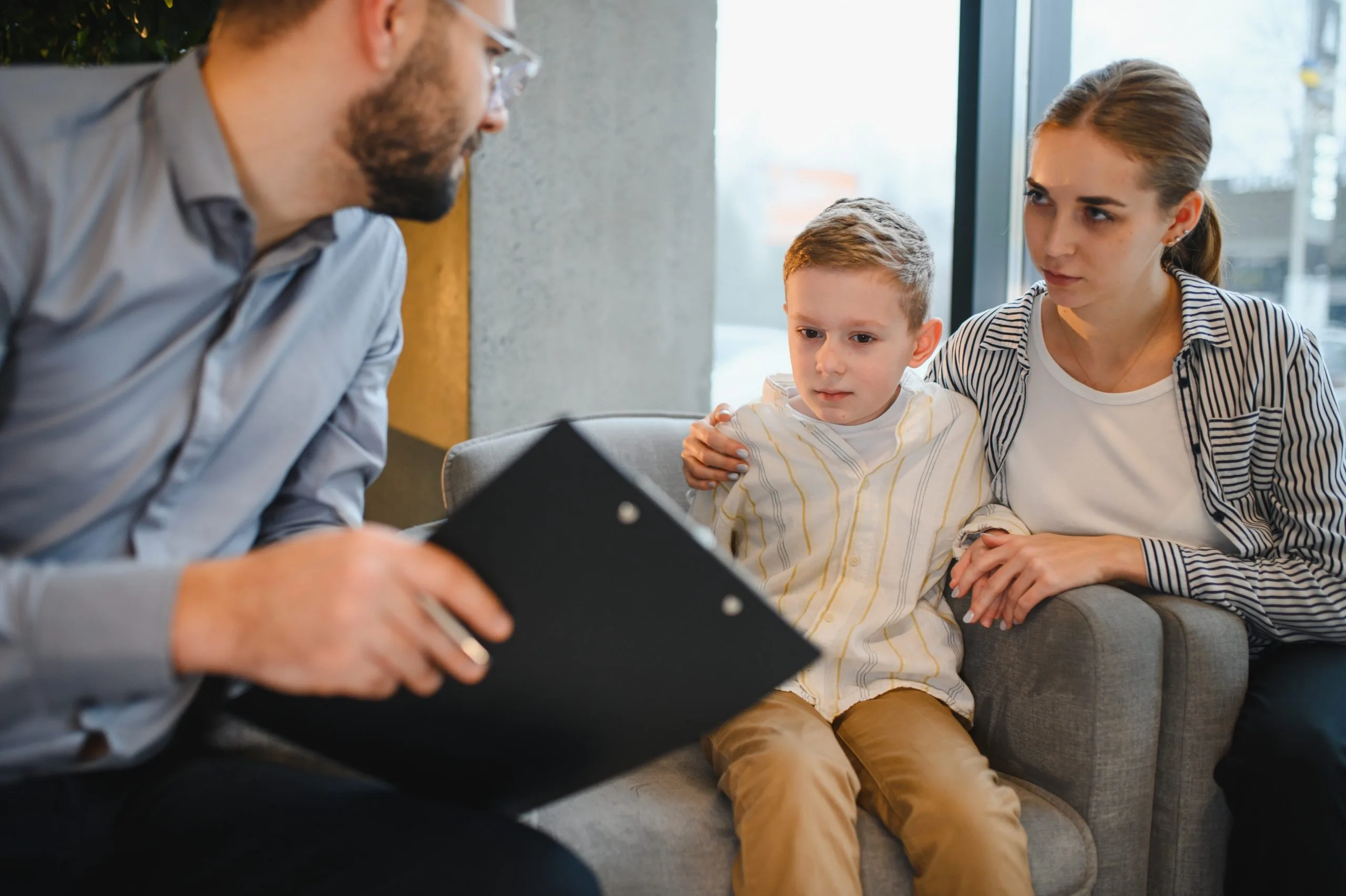 Parents and young son meeting a child therapist
