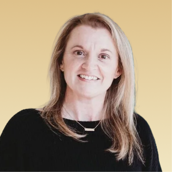 Jill Flannery, team member, smiling at camera against yellow background