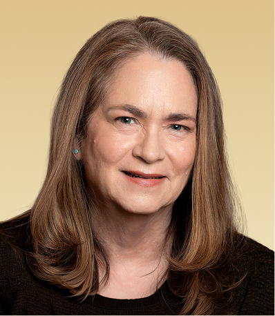 Woman with long brown hair wearing black top against tan background