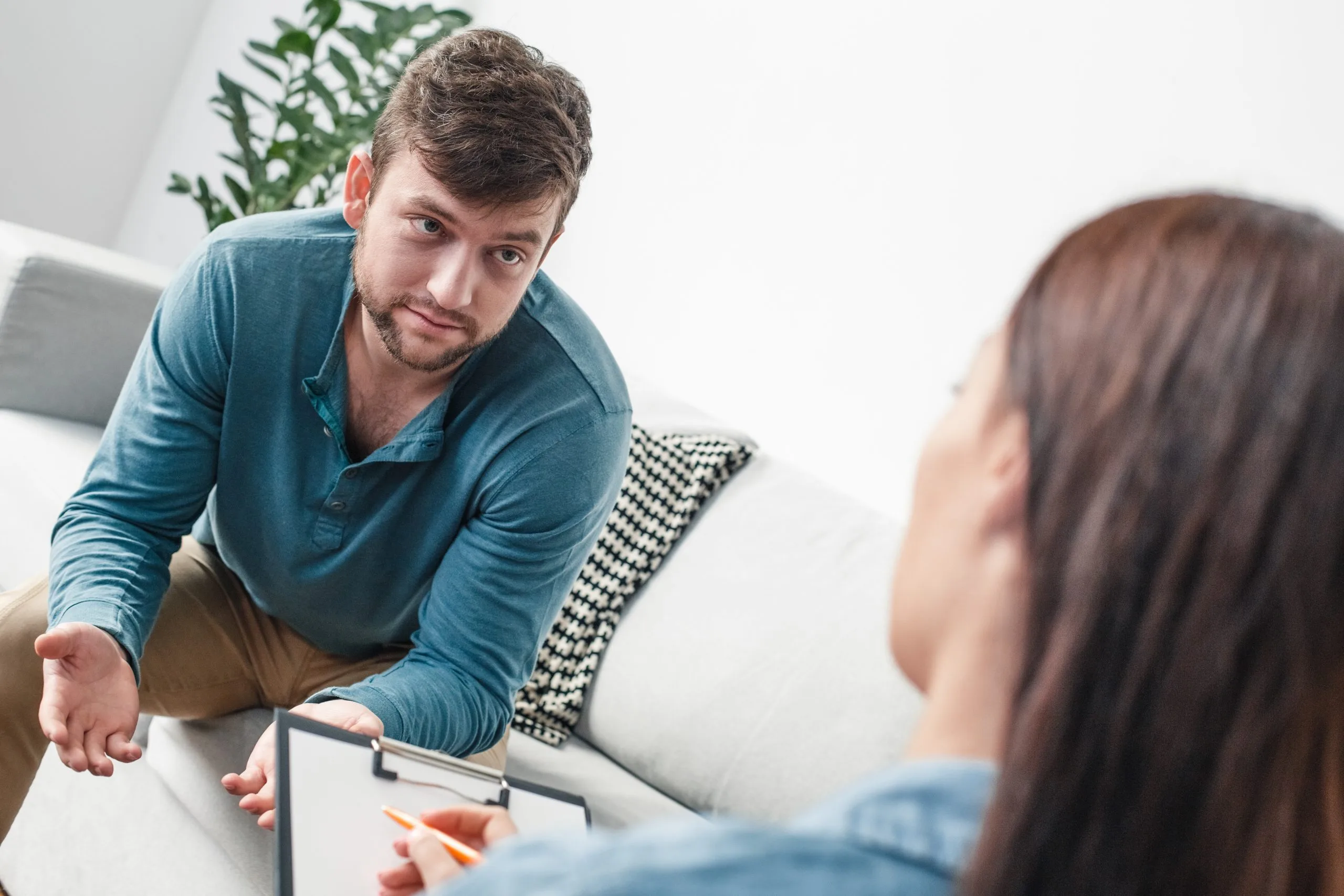 Therapist listening attentively to a patient during a counseling session in a bright office setting