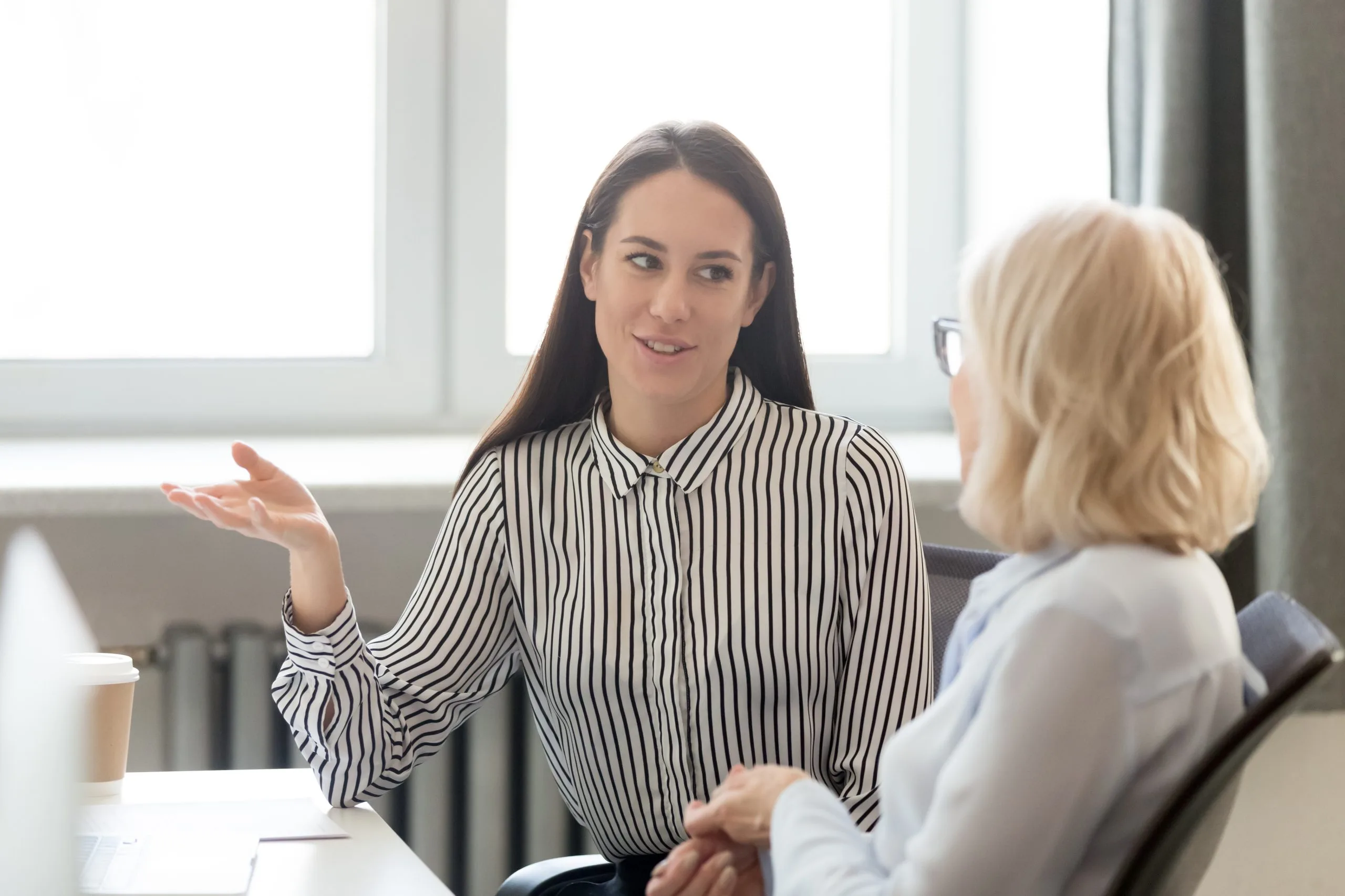 Therapist speaking with a patient during a consultation in a bright office