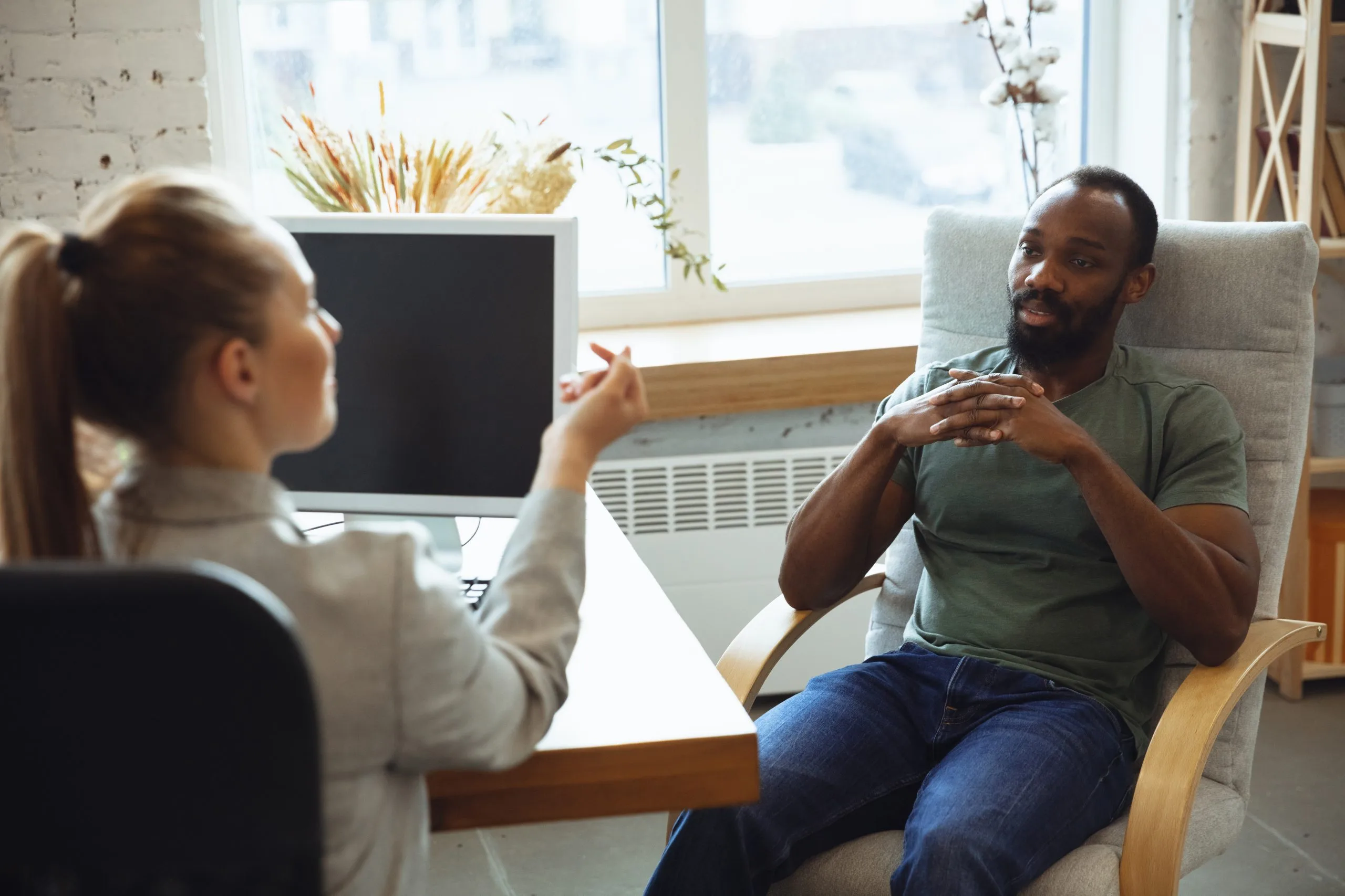 Therapist and male patient in discussion during a medication management consultation in a bright office