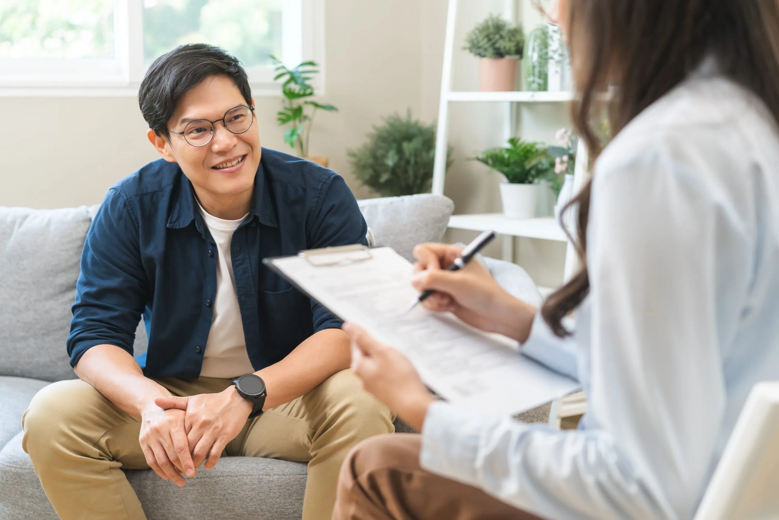 Patient in blue shirt speaking with healthcare provider in white coat during medication management consultation