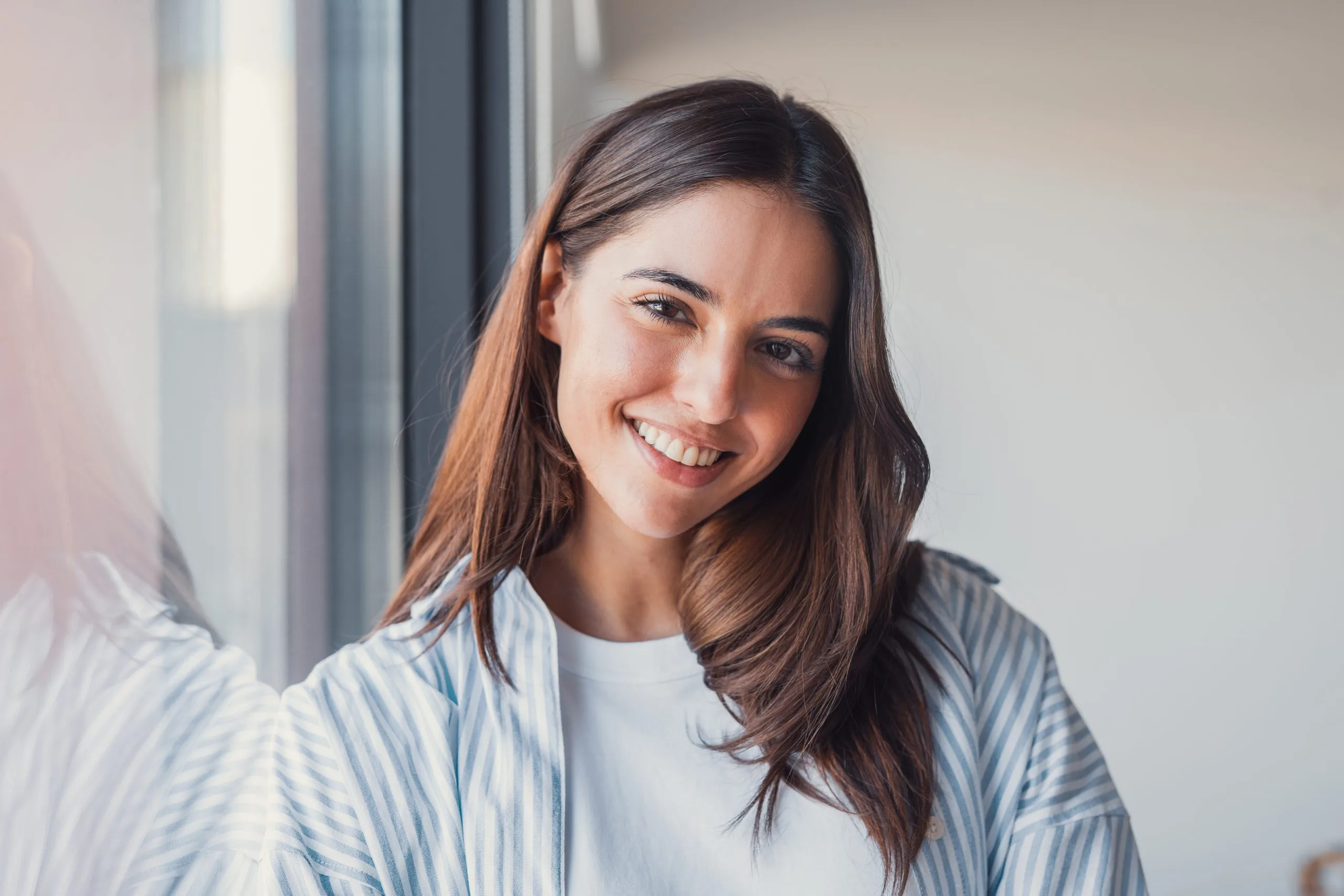 Smiling woman by a window in natural light