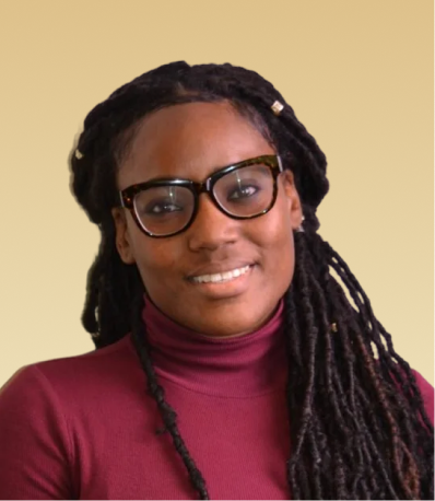 Team member wearing glasses and maroon turtleneck against tan background