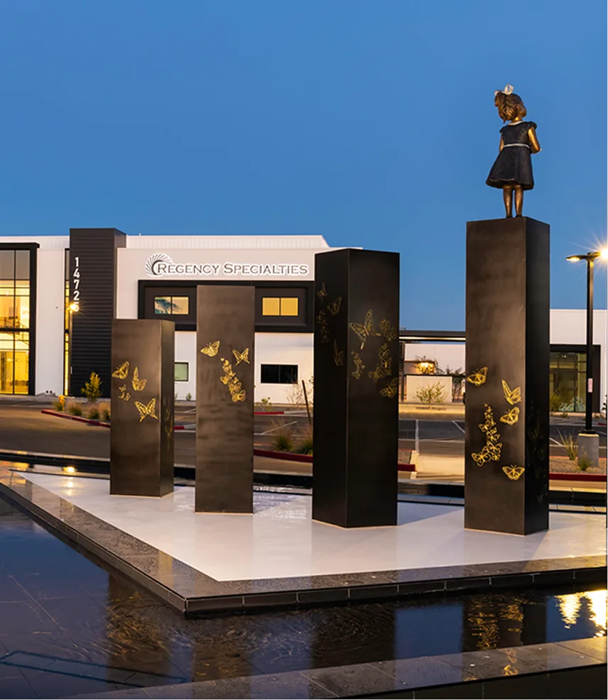 Regency Specialties medical building exterior at dusk with butterfly sculptures and logo visible