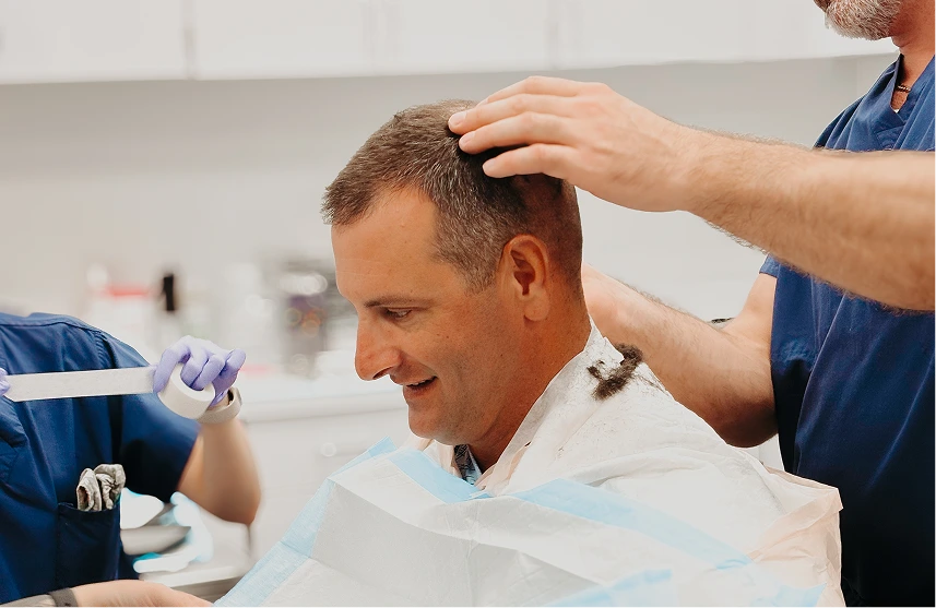 Clinician examining patient's scalp during hair restoration consultation