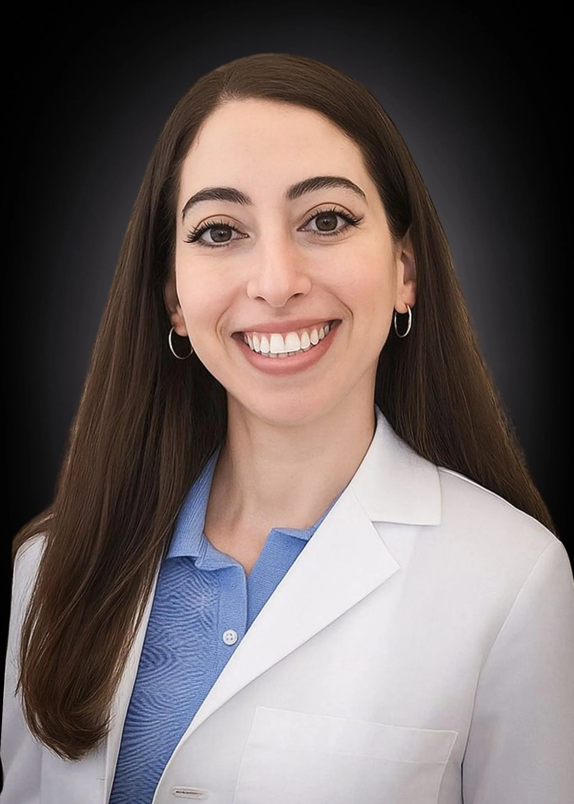 Professional headshot of female staff member smiling, wearing white coat and blue shirt