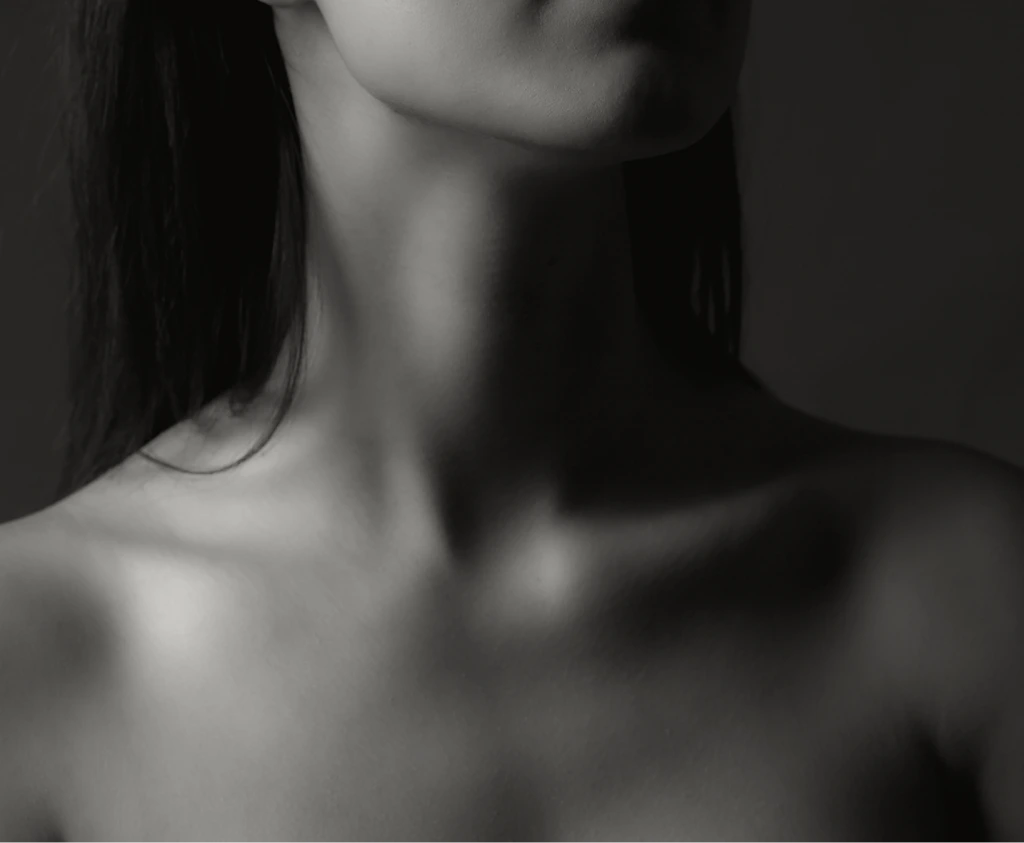 Woman with long dark hair in profile showing neck and jawline definition, black and white portrait