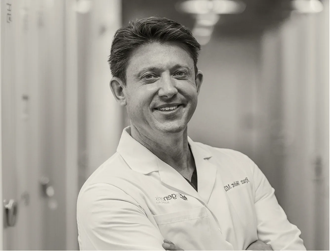 Surgeon in white medical coat smiling in a clinical setting