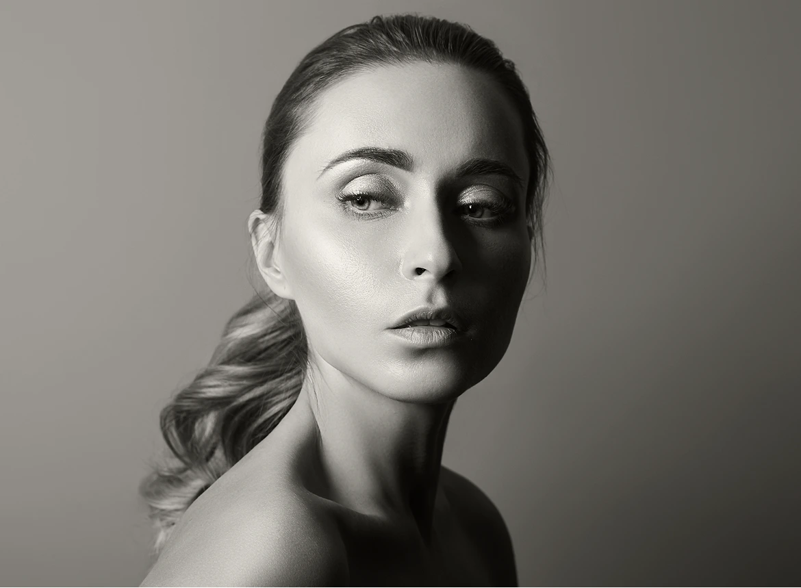 Woman's face in three-quarter view with side lighting showing facial contours