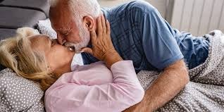 Older couple kissing in bed together