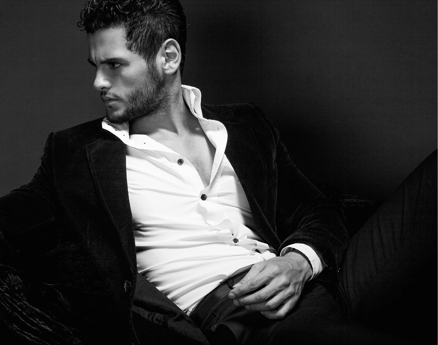 Man in black blazer and white dress shirt looking to the side in black and white portrait