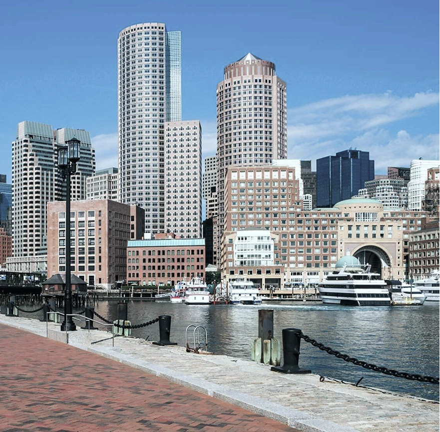 Boston waterfront skyline with tall buildings and docked yacht