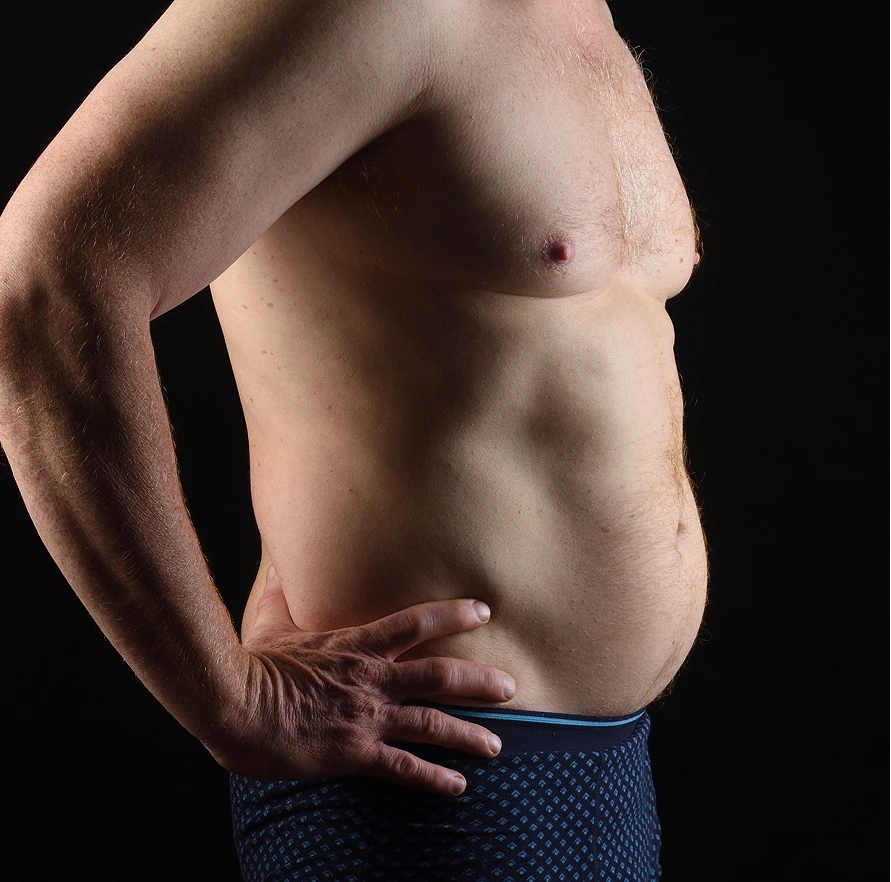 Man with hands on abdomen showing body composition
